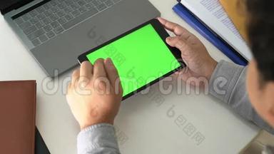 商务<strong>男士手拿</strong>平板电脑在办公室绿色桌面屏幕上的4k视频